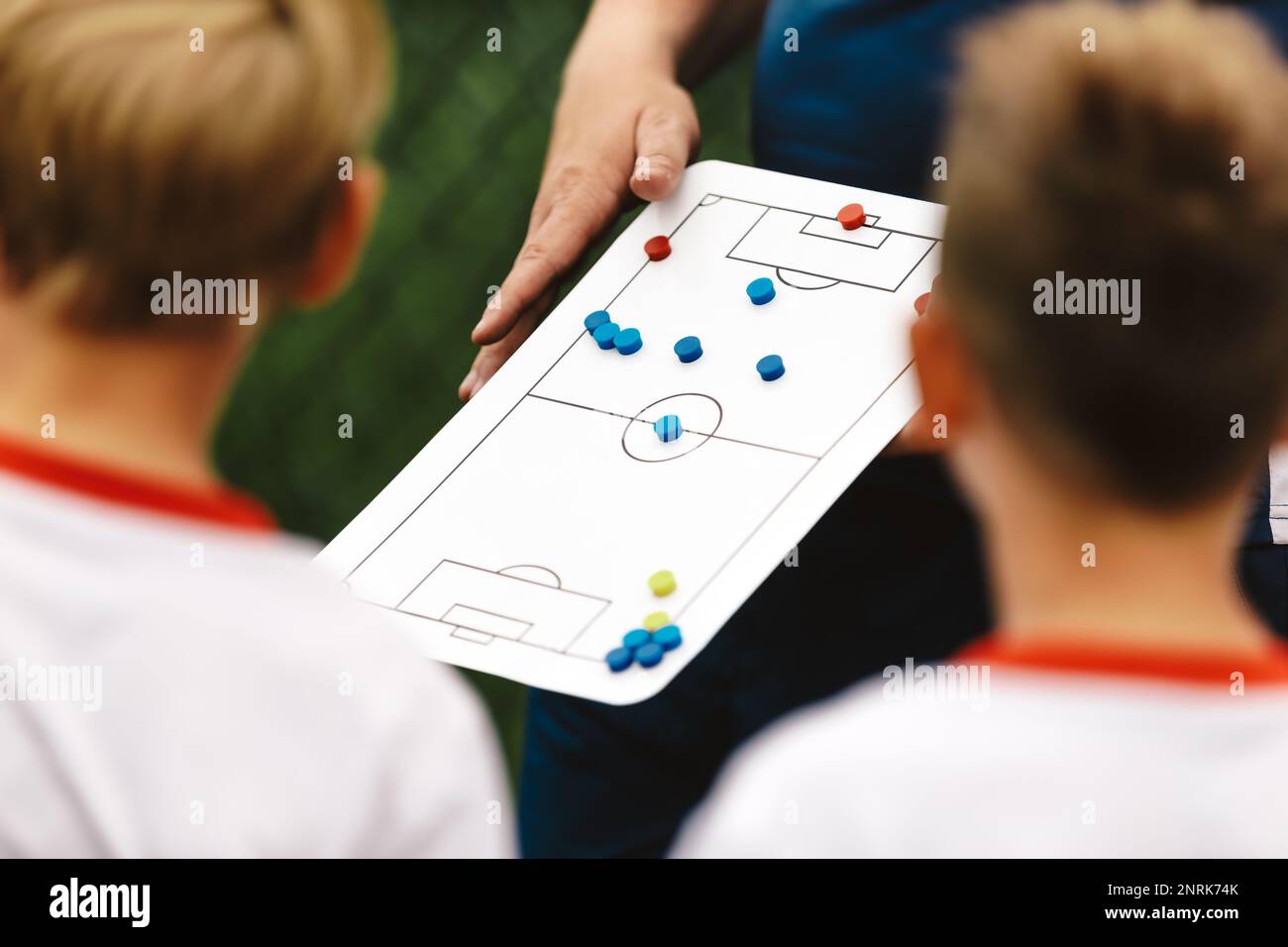 Soccer Coach Holding Tactics Board Football Tactics Board Strategy in Soccer. Coaching Kids Soccer. Football Team with Coach at the Stadium Stock Photo