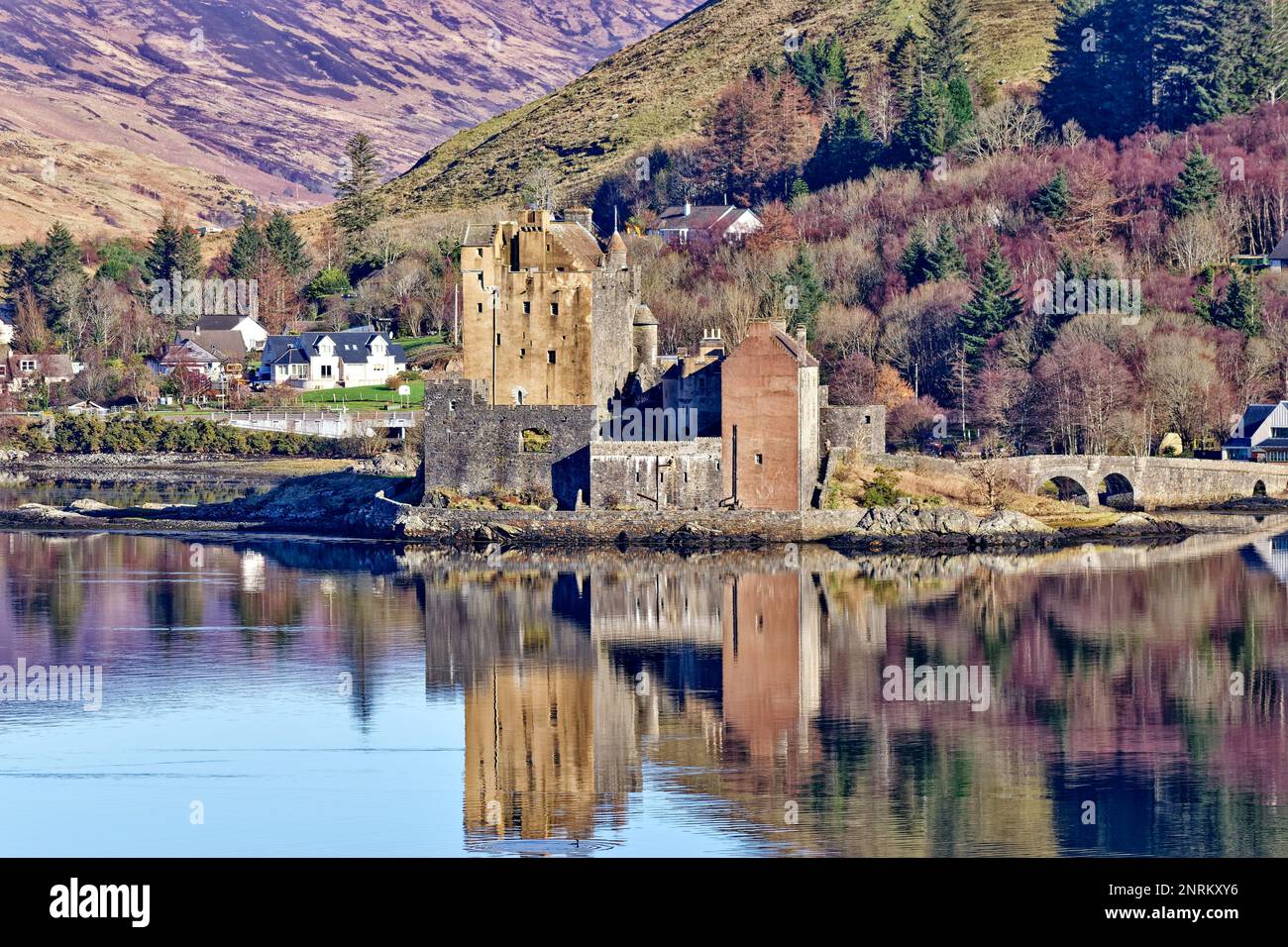 Eilean Donan Castle Loch Duich Scotland the many colours of the castle and birch trees reflected in the sea loch Stock Photo