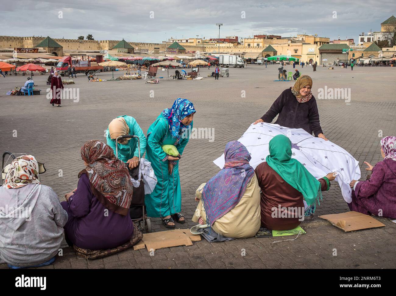 Women and woman selling handmade tablecloth with traditional motifs. In El Hedim Square, Meknes, Morocco Stock Photo