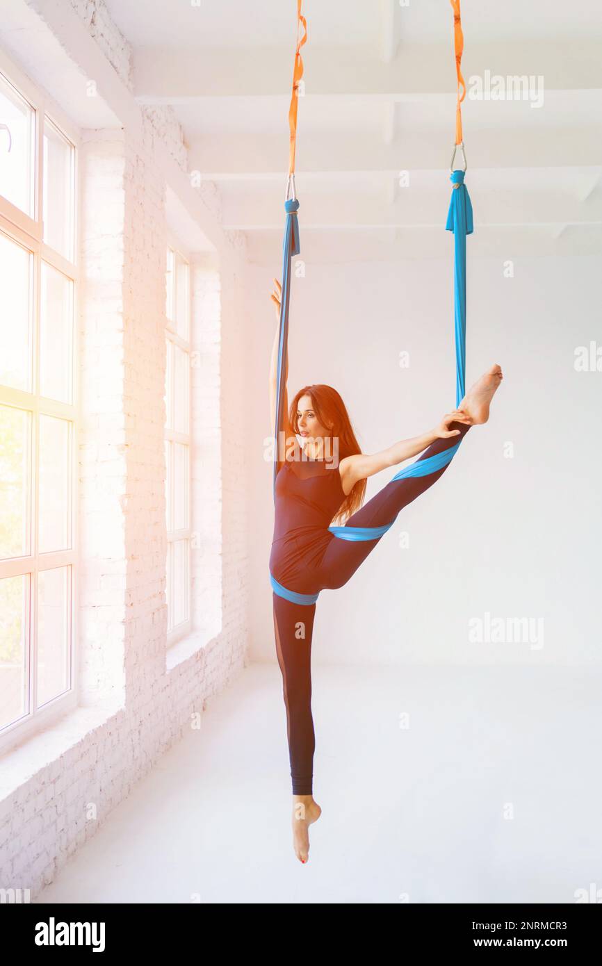 Pole acrobatics exercise for fitness in gym of training studio