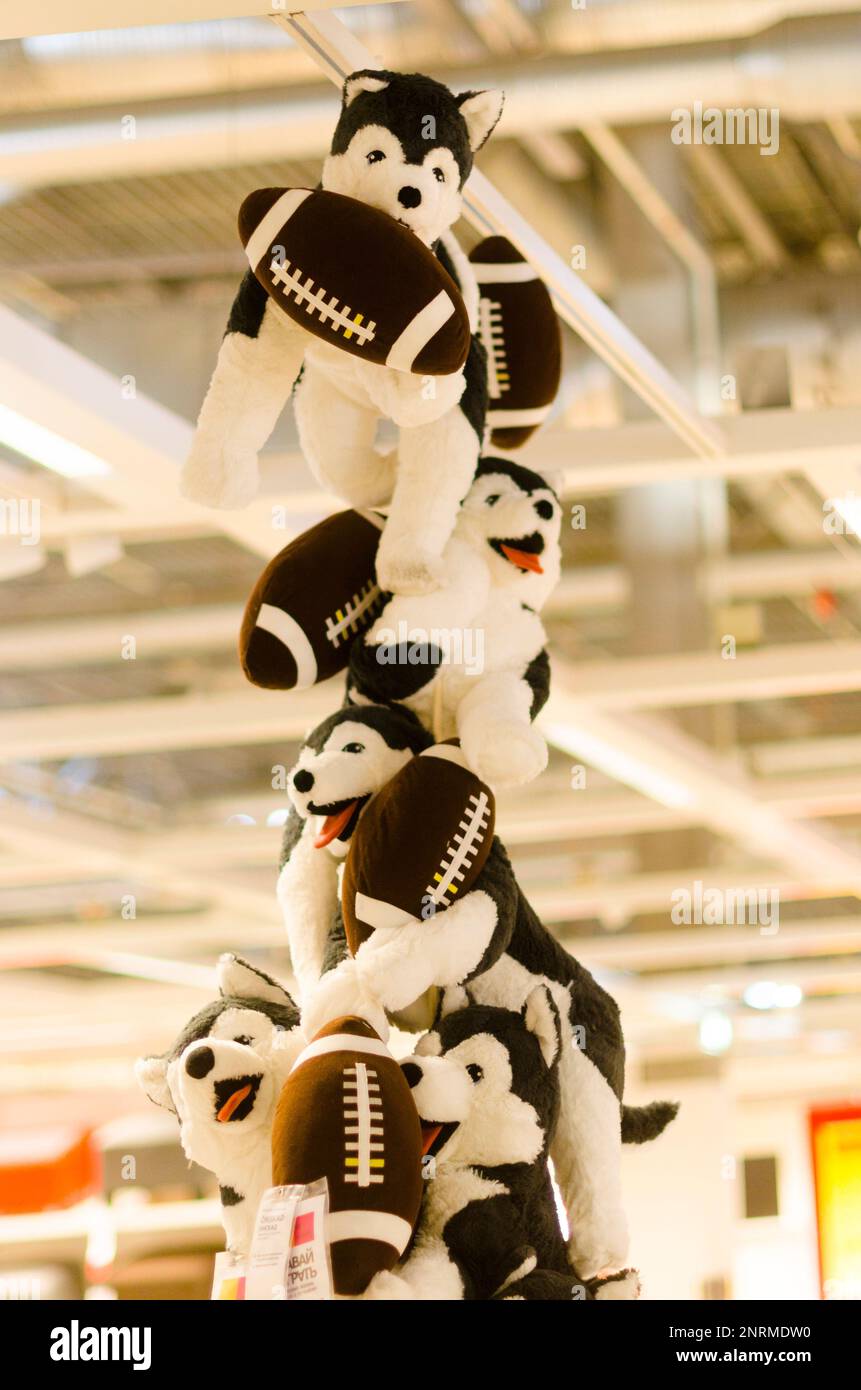 Many toy bears dogs hang in a row, holding hands to the ceiling in the store 'IKEA' in Russia Stock Photo