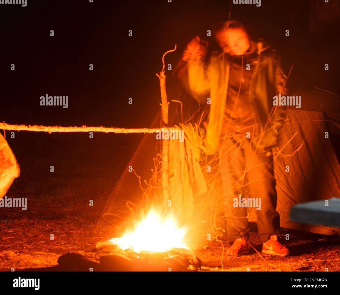 The abstract photograph of lights campsites with fire and silhouettes of people. Soft focus. Stock Photo