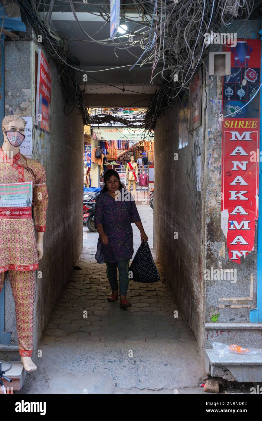 Kathmandu, Nepal, 04 23 2022 Woman with groceries walking through an