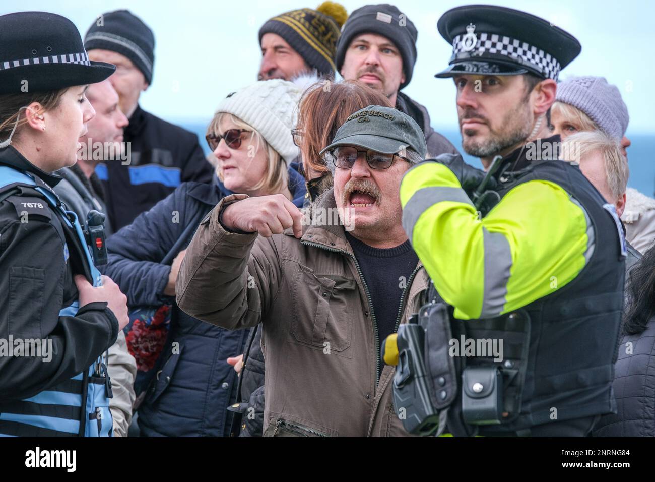Devon and Cornwall police liaison officer dealing with an angry man demonstrating against asylum seekers being housed in the Beresford Hotel in Newqua Stock Photo