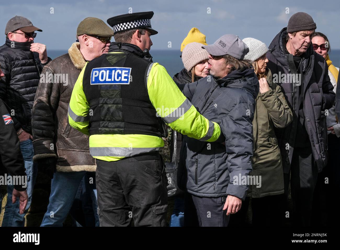 A police officer controlling an angry protester at a demonstration organised by the right wing group Reform UK against asylum seekers placed in the Be Stock Photo