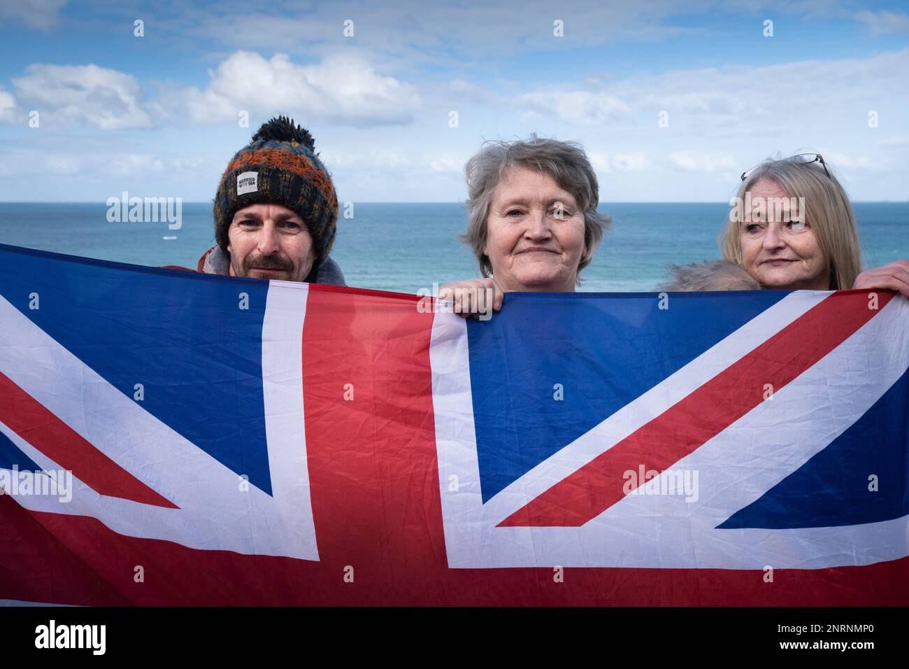 People holding up the Union Flag Union Jack at a demonstration organised by the right wing group Reform UK against asylum seekers placed in the Beresf Stock Photo