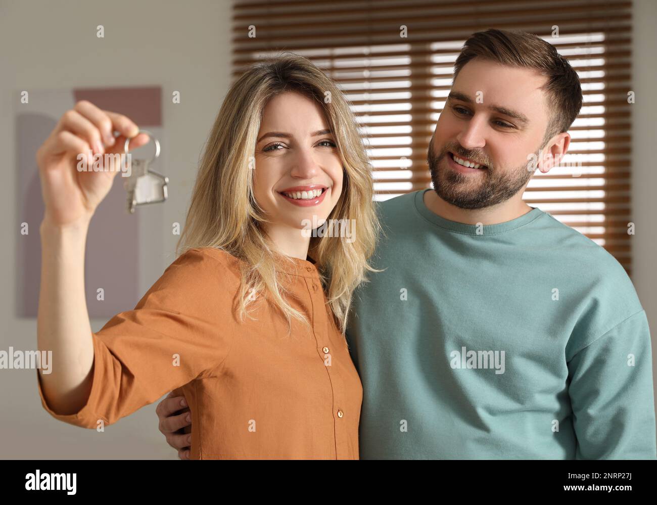 Happy young couple with key in new house Stock Photo - Alamy