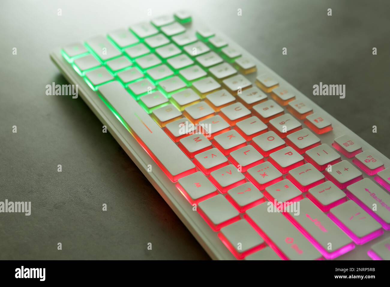 Modern keyboard with RGB lighting on grey table, closeup Stock Photo