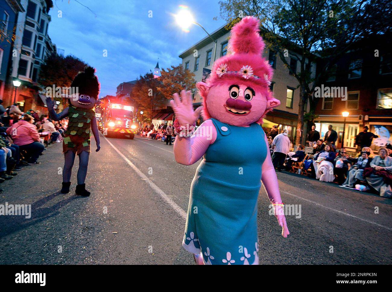 Characters from the animated movie "Trolls" wave to the crowd along