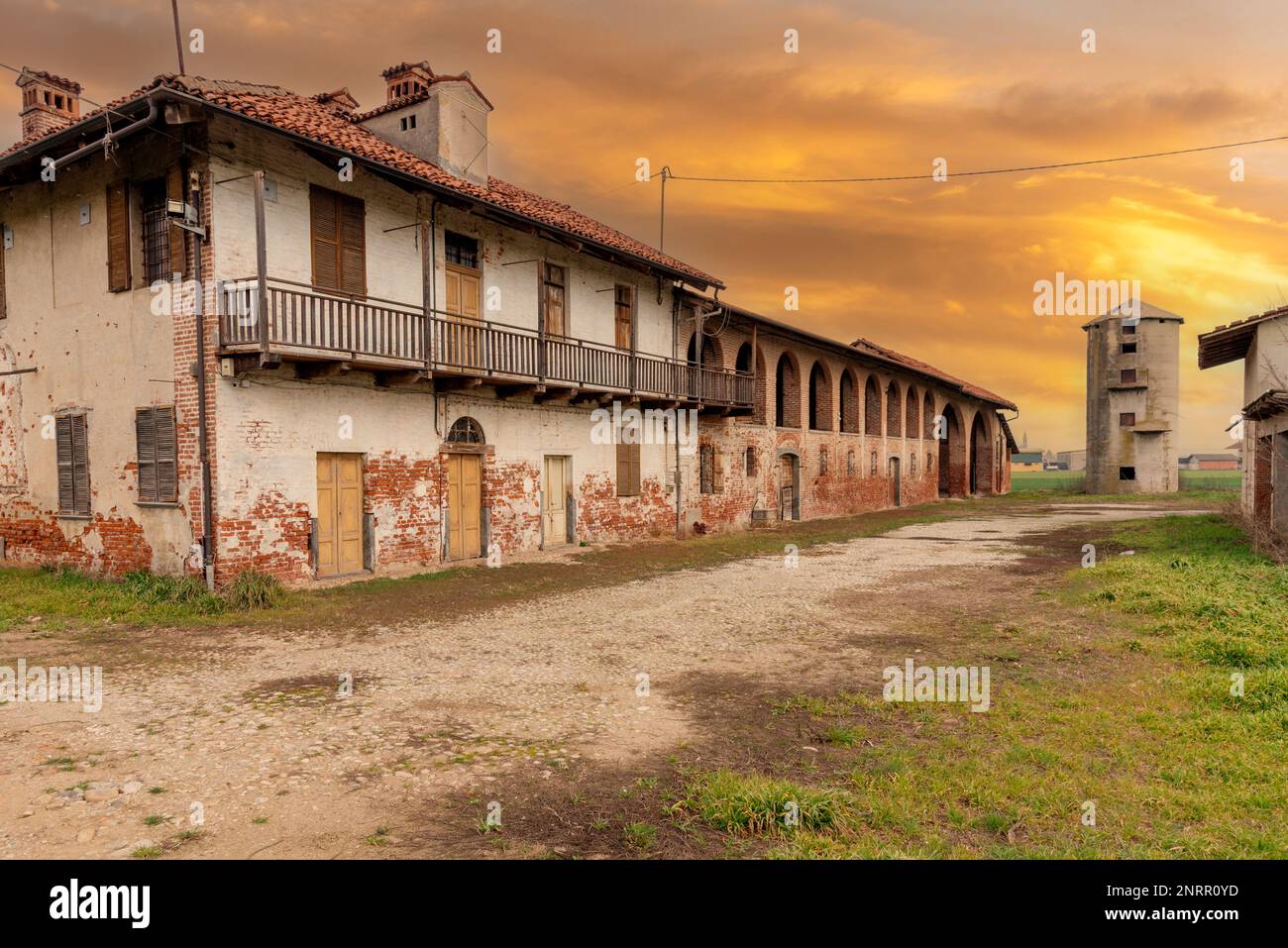 Old abandoned farmhouse with typical rural architecture of the Po Valley in the province of Cuneo, Italy. Rural dwelling with stable and barn under br Stock Photo