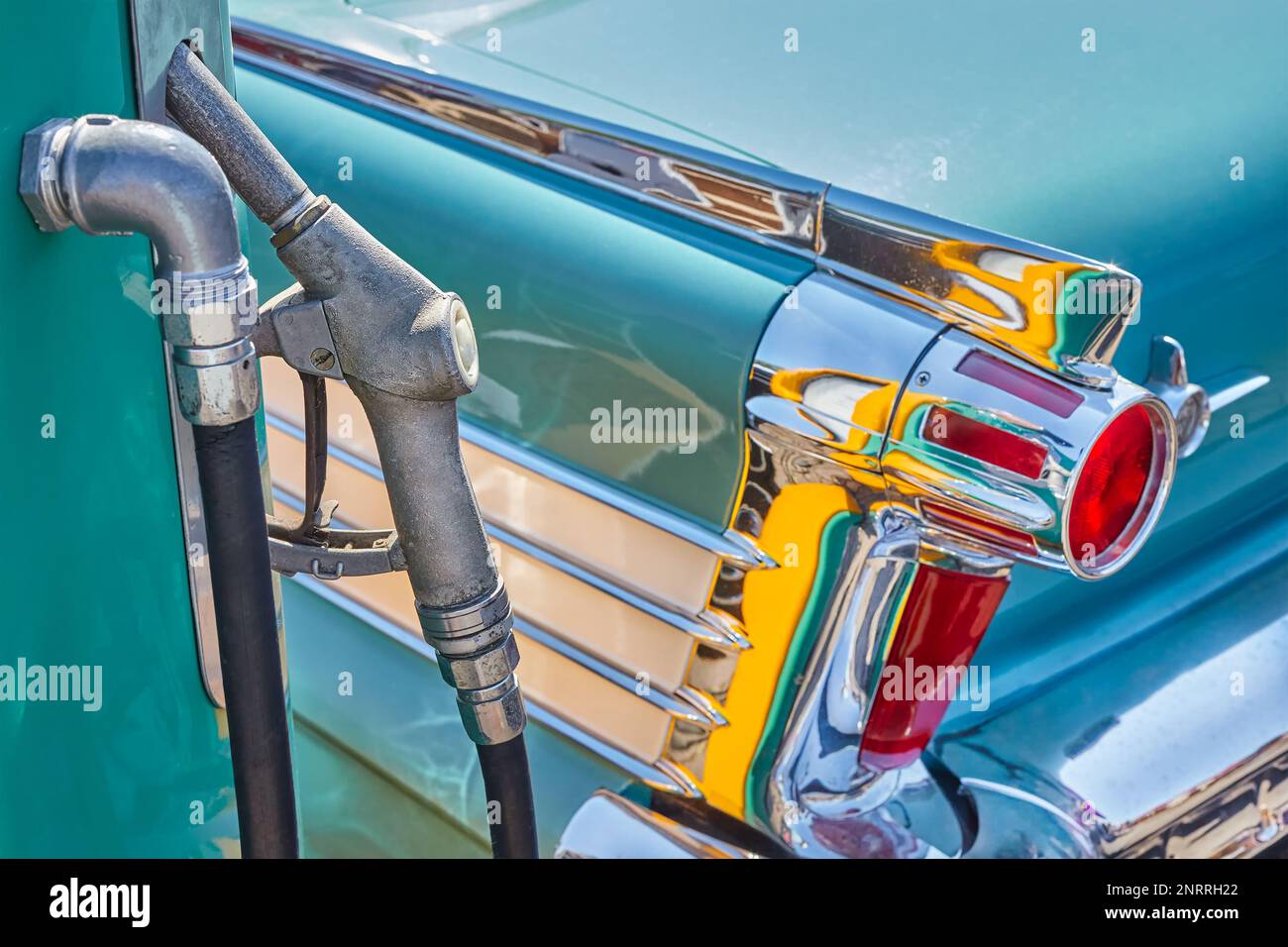 Retro styled image of an old fuel pump and green classic car Stock Photo