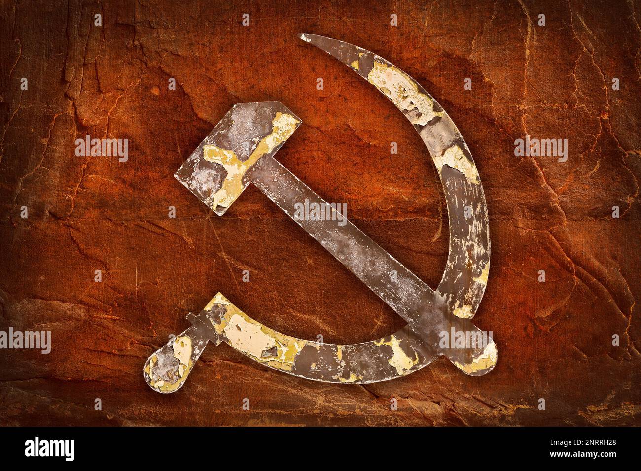 Weathered USSR hammer and sickle in front of an old brown background Stock Photo
