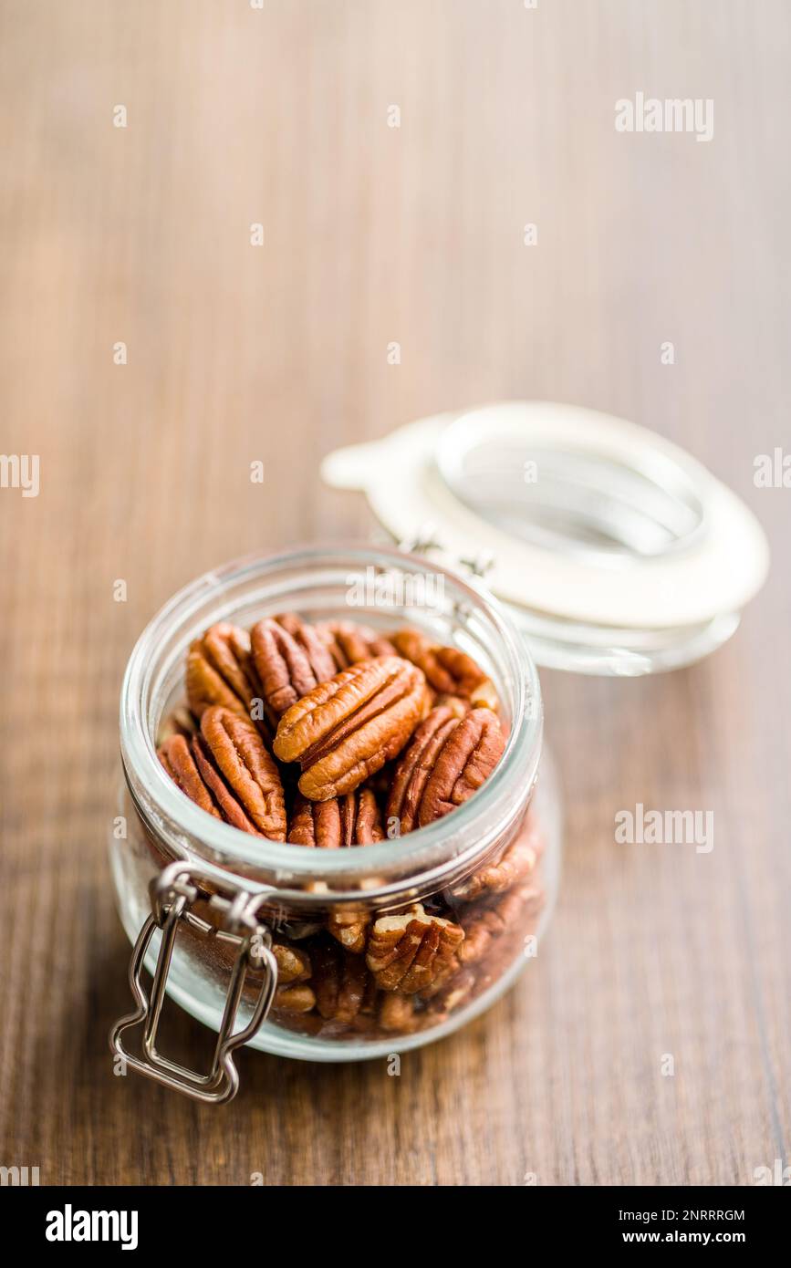 Peeled pecan nuts in jar on the kitchen table. Stock Photo