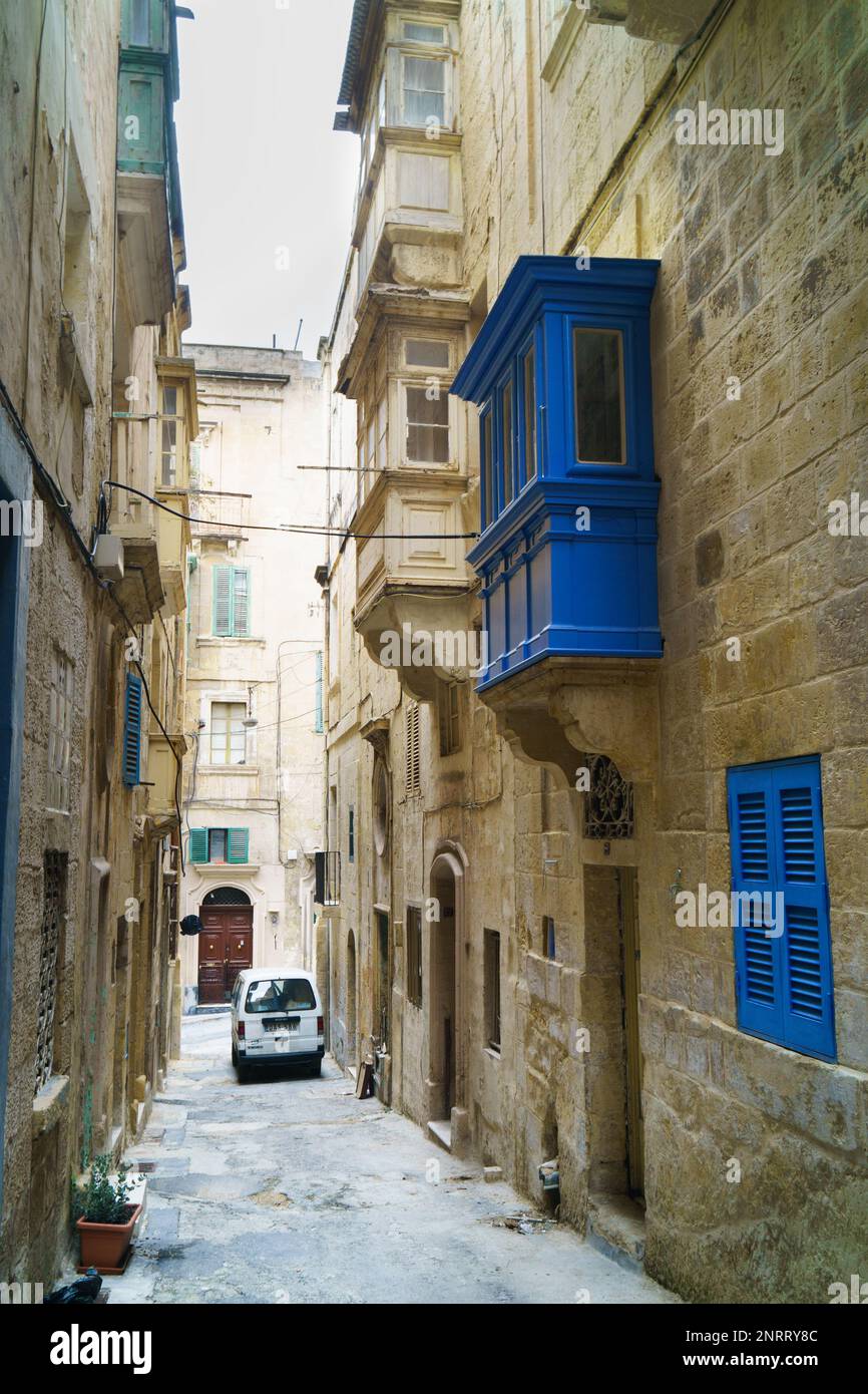 Valletta, Malta - November 27, 2017 Medieval old town typical narrow street with cars in the city Valletta, Malta. Colorful blue, green balconies and Stock Photo