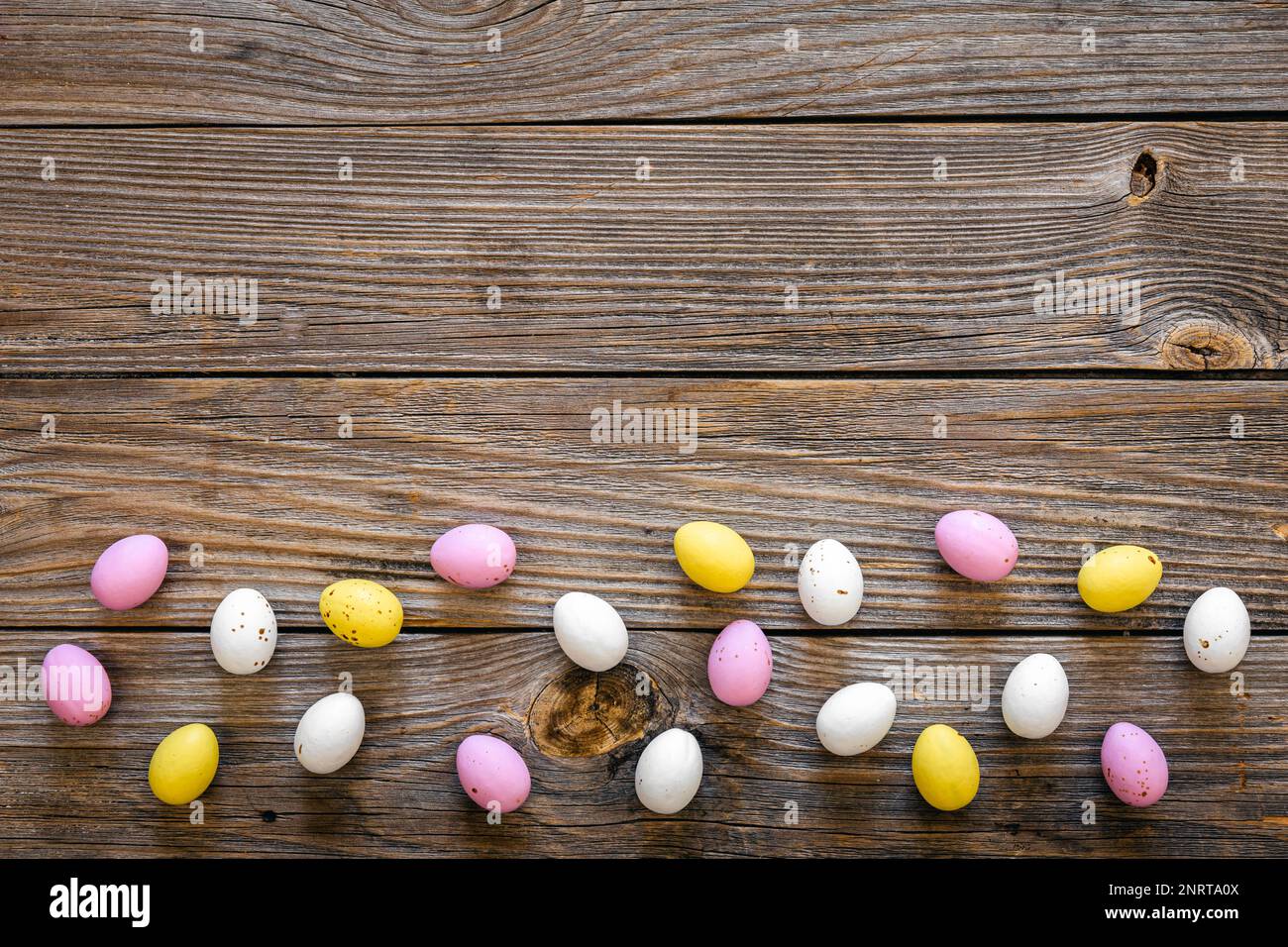 Multicolored Easter eggs on a wooden background, flat lay. Stock Photo