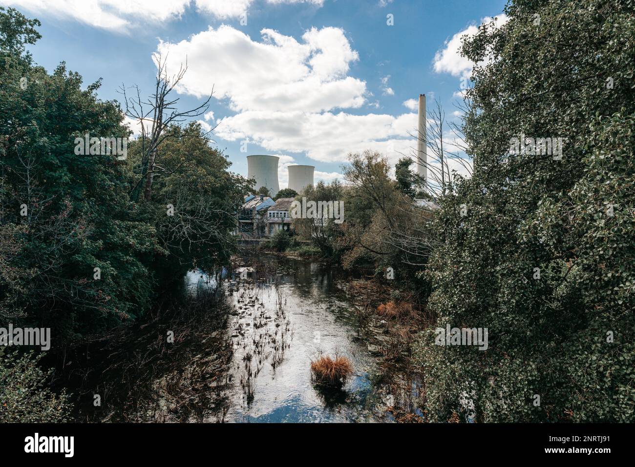 Energy production plant with coal behind a river with clean water Stock Photo