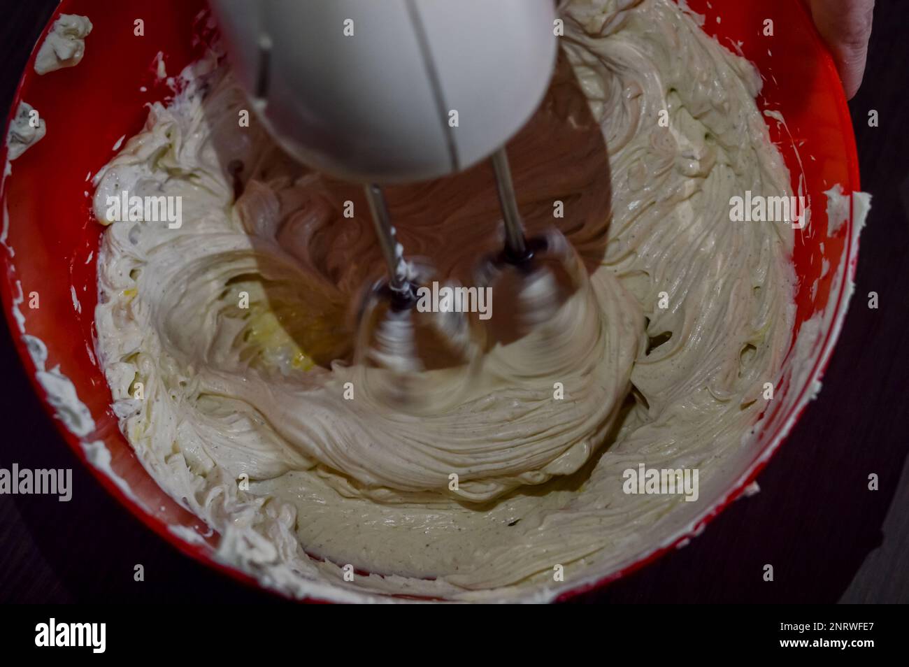 blender mixing fresh white cheese and eggs to make cheesecake cream