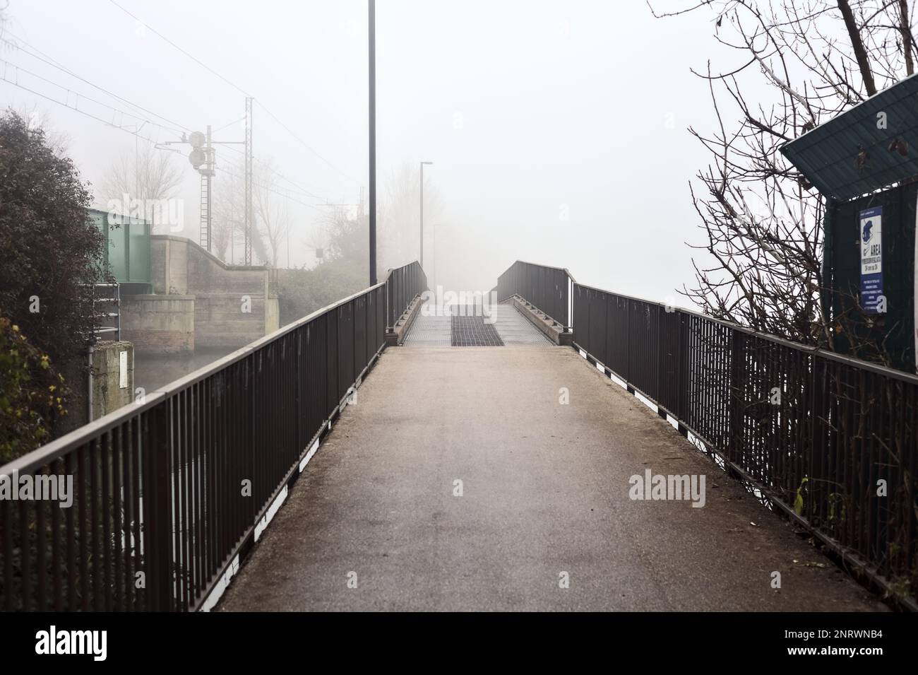 Bridge on a lake that leads to a grove on a foggy day in winter Stock ...