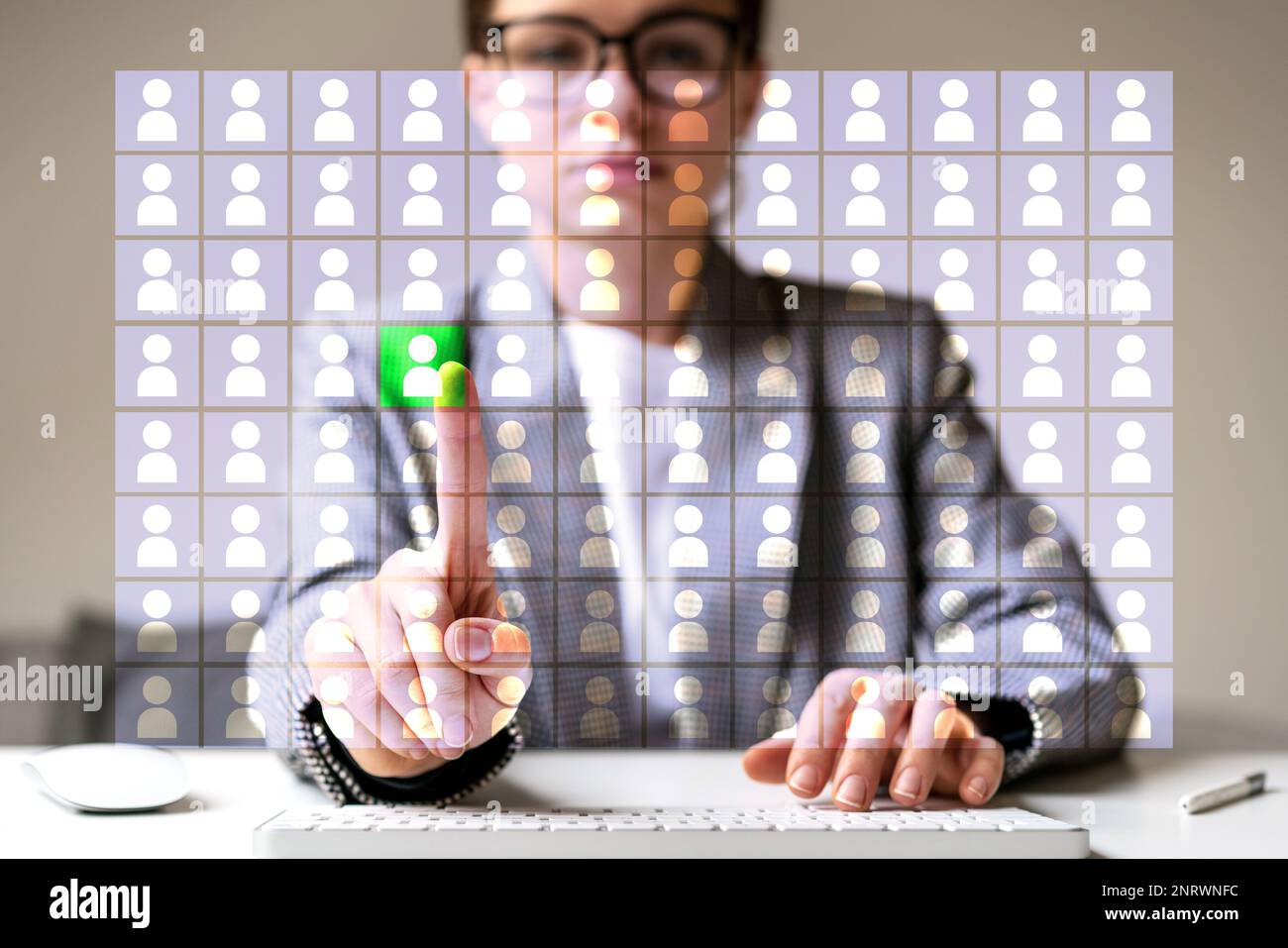 Human Resources specialist touching icon of employee with her finger on virtual screen. Stock Photo