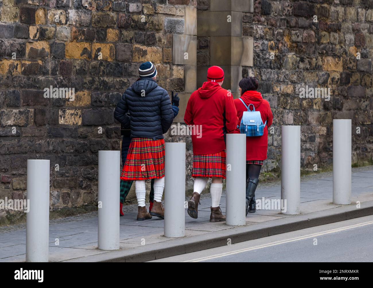 People walking up Royal Mile wearing Scottish kilts and tartan, Edinburgh, Scotland, UK Stock Photo