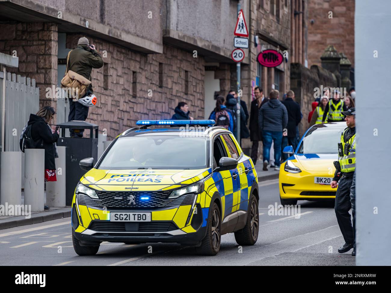 Photographer taking photo of march on Royal Mile with police car, Edinburgh, Scotland, UK Stock Photo