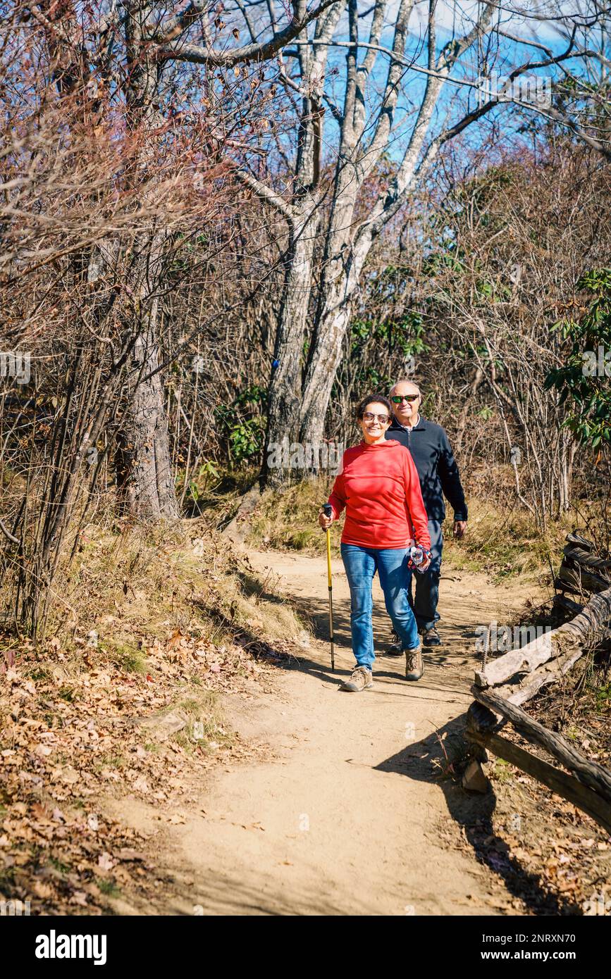 Senior couple is hiking in the woods in North Carolina in fall Stock Photo