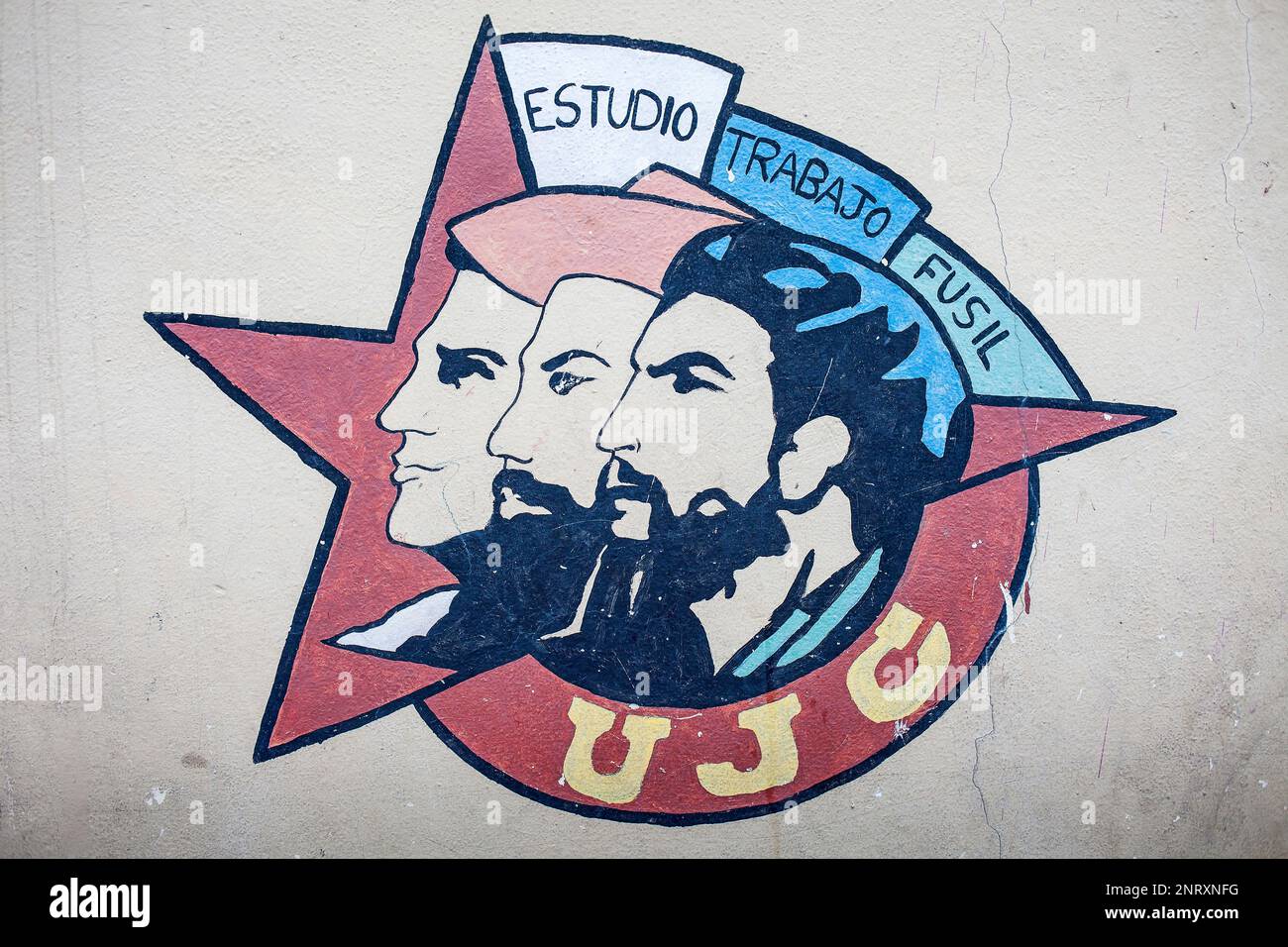 Political propaganda. Emblem of UJC, Union of Young Communists, faces of Mella, Cienfuegos y Che, painted on a street wall, La Habana, Cuba Stock Photo