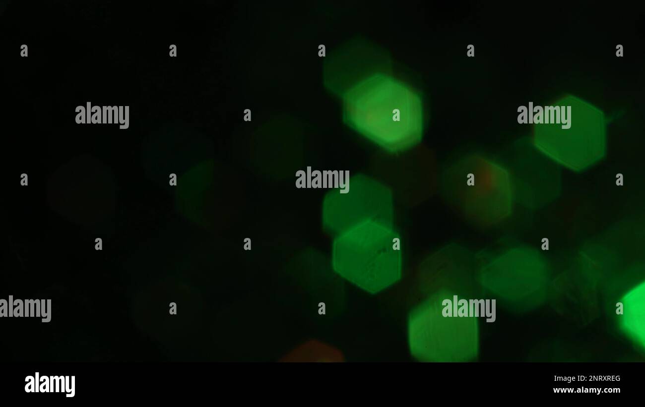 Particles of natural organic green dust floating on a black background