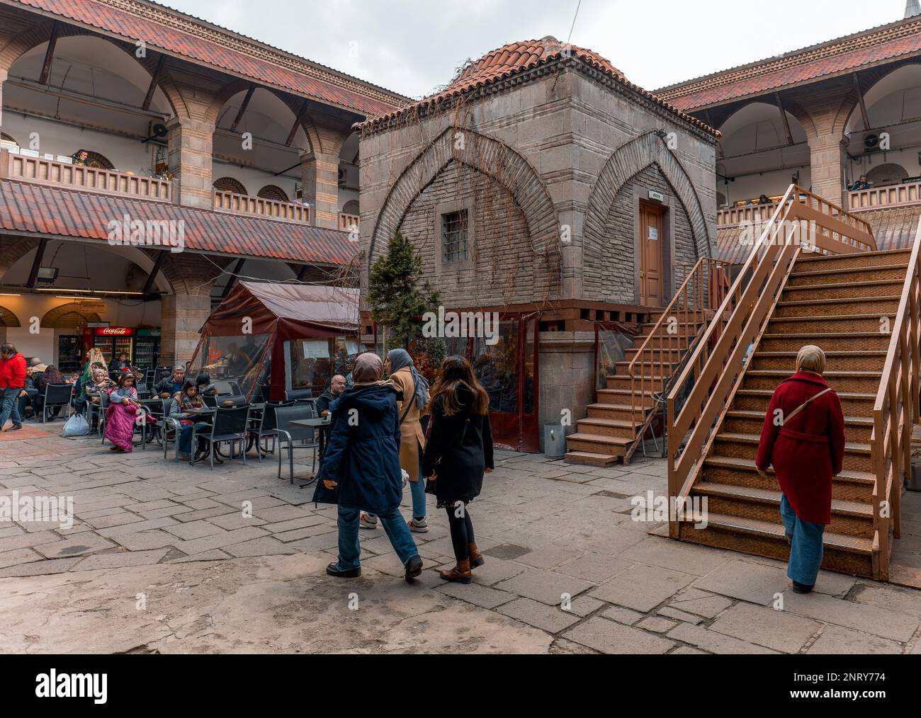 Ankara-Turkey: February 25, 2023: Local people and tourists shopping or sitting at cafe and talking in historical Suluhan caravanserai, constructred b Stock Photo