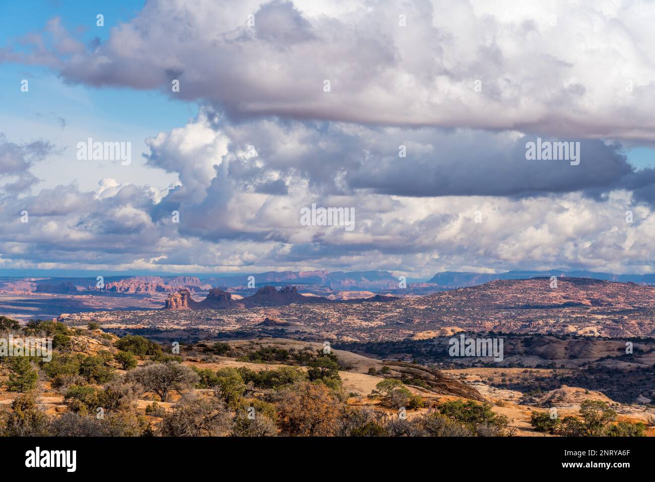 Cumulus clouds over Arth's Pasture, Arth's Rima & distant Arches National Park from the Plateau Viewpoint, Moab, Utah. Stock Photo