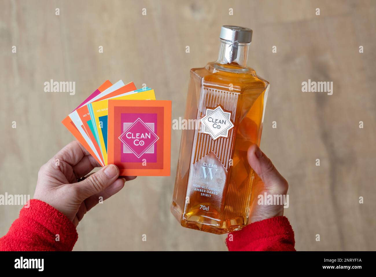 A woman holds a 70cl bottle of CleanCo Clean W. A non alcoholic whisky alternative. One of a new range of non alcoholic crisp dry botanical spirits Stock Photo
