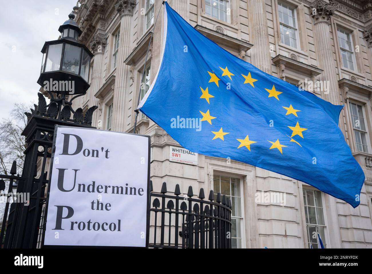 On the day that British Prime Minister Rushi Sunak's government finally reached a post-Brexit trade deal with the EU, a renegotiation of the Northern Irish Protocol, the EU flag flies above pro-Europe protesters at the gates to Downing Street, on 27th February 2023, in London, England. Stock Photo