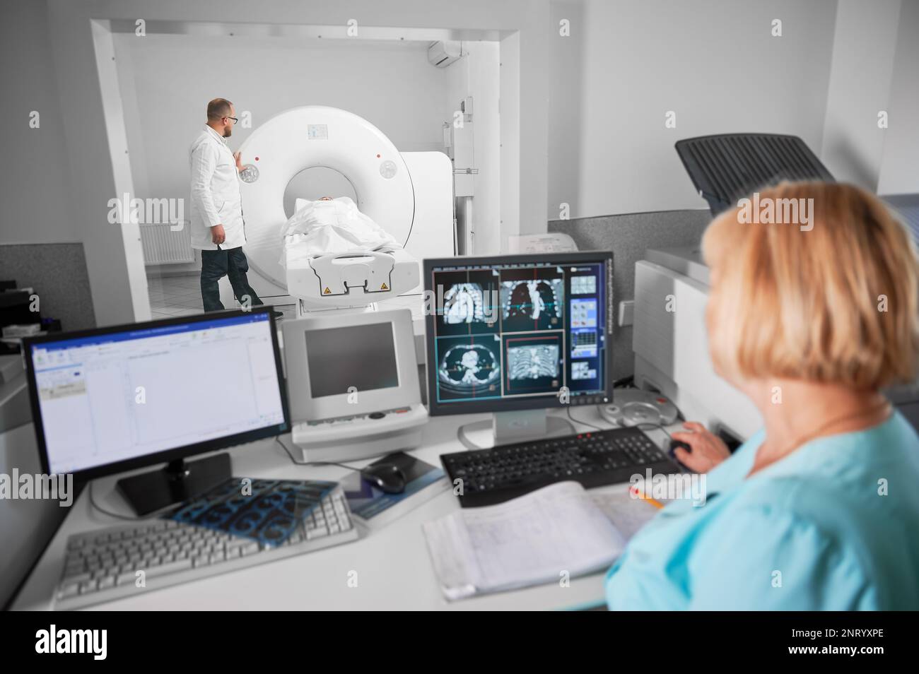 Medical computed tomography or MRI scanner. Back view of blonde nurse
