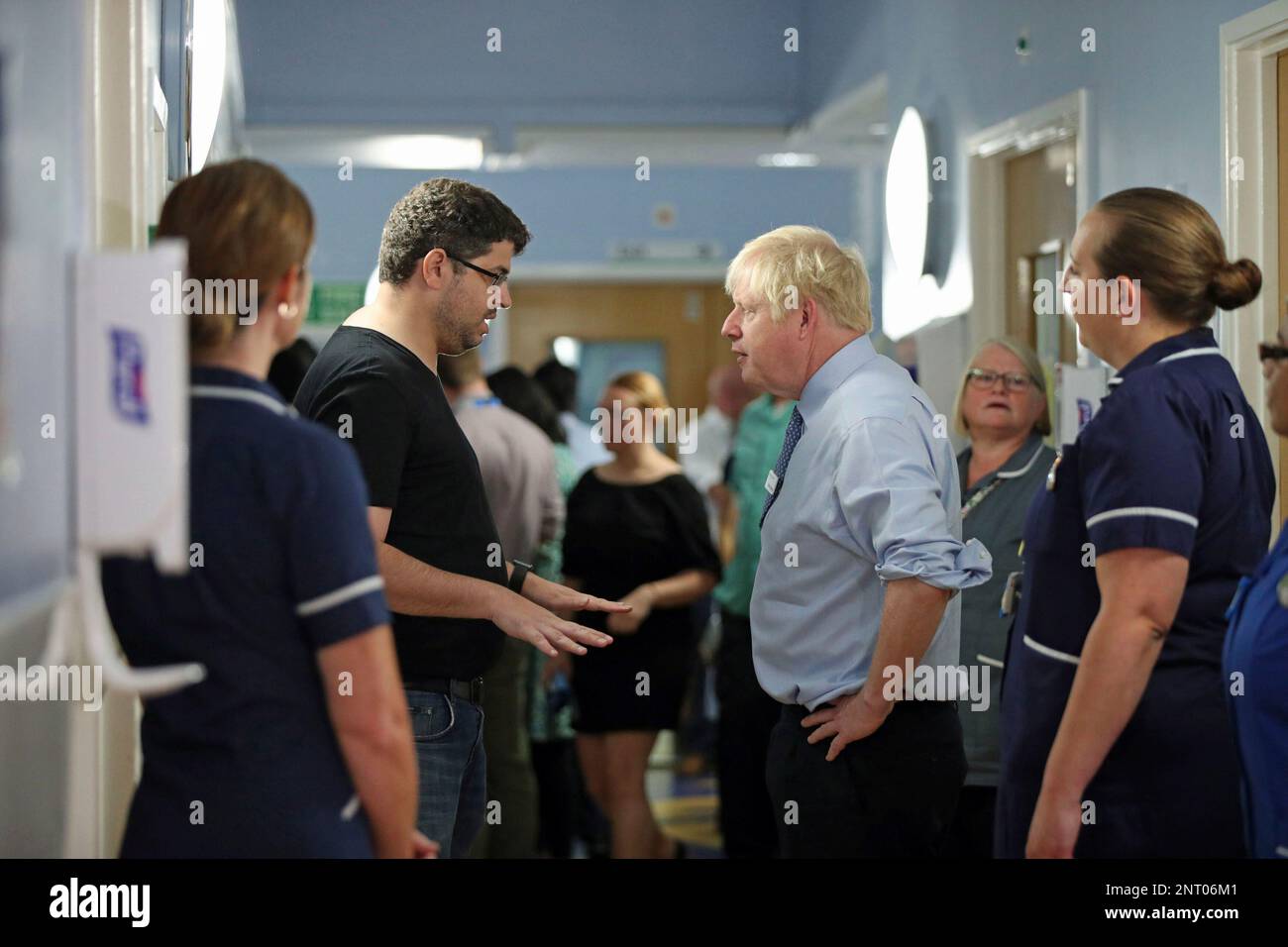 The father of a young patient, who is being treated in the Acorn children's  ward, talks to Britain's Prime Minister Boris Johnson during his visit to Whipps  Cross University Hospital in Leytonstone,