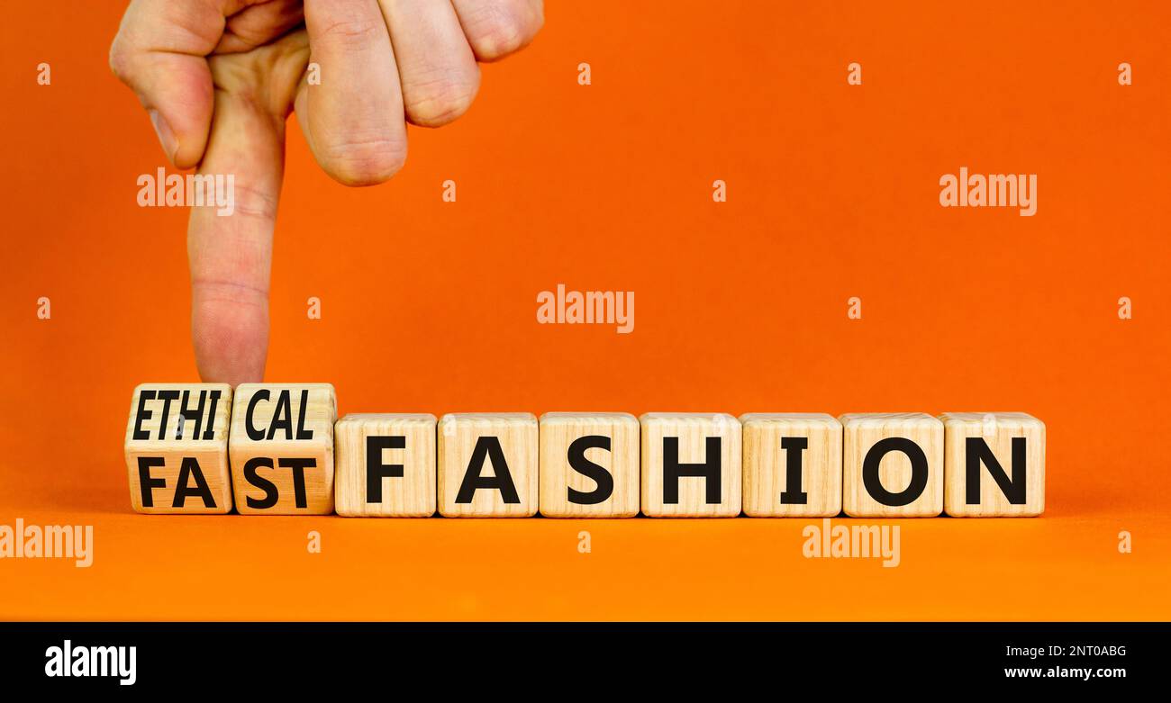Fast or ethical fashion symbol. Concept words Fast fashion and Ethical fashion on wooden cubes. Businessman hand. Beautiful orange background. Busines Stock Photo