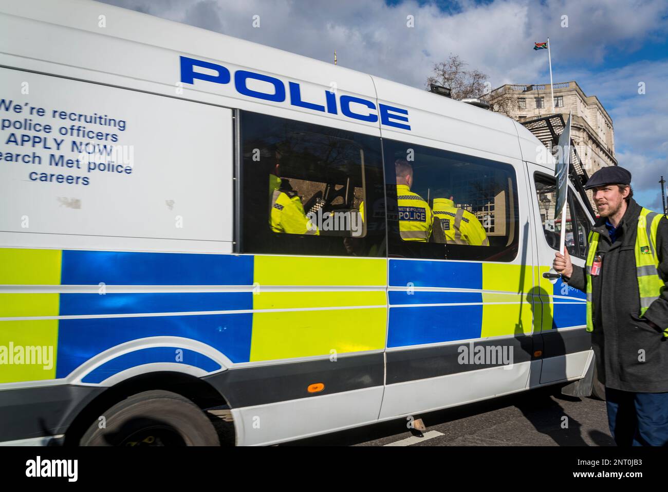 Police van with police officers inside and a lone protestor with a political placard, , London, England, UK Stock Photo