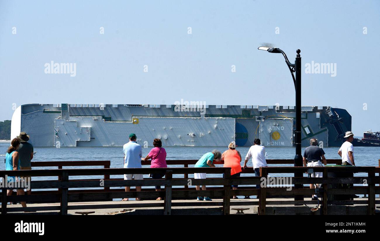 People look at a capsized cargo ship off the St. Simons Island Pier
