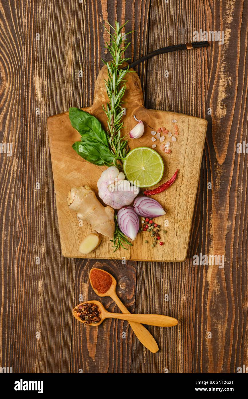 Composition with different spice and seasonings for cooking on wooden cutting board Stock Photo