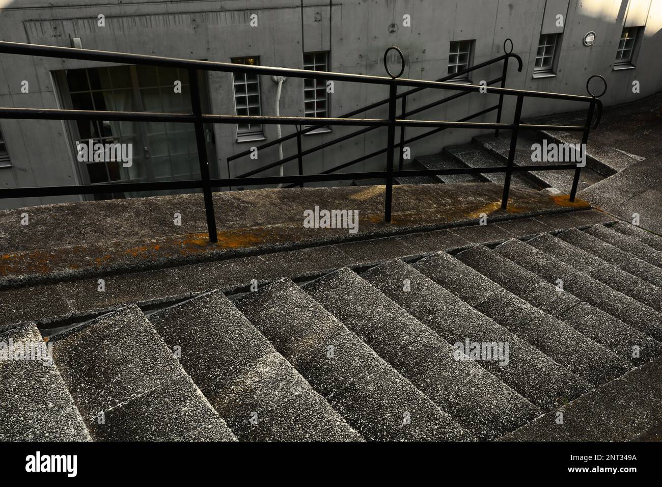 Concrete staircase with a retro and modern design on a dimly lit slope Stock Photo