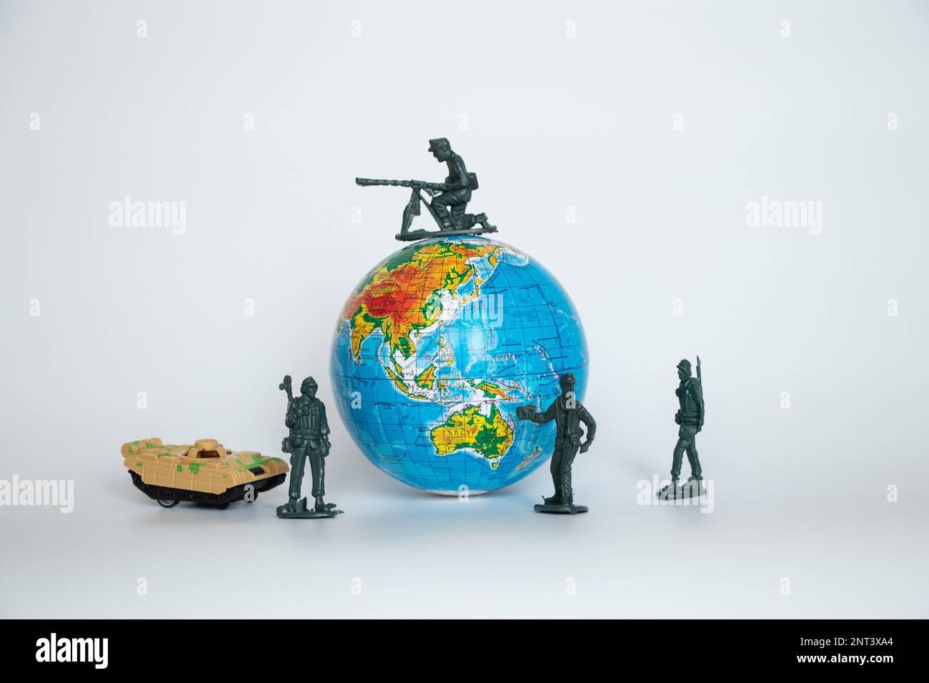 Globe in Ukrainian and plastic soldiers and tank children's toys on a white background close -up, army Stock Photo