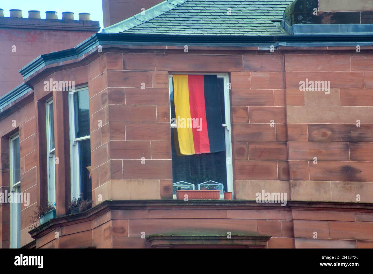 german flag on red sandstone tenement window on the A82 great western road Glasgow, Scotland, UK Stock Photo