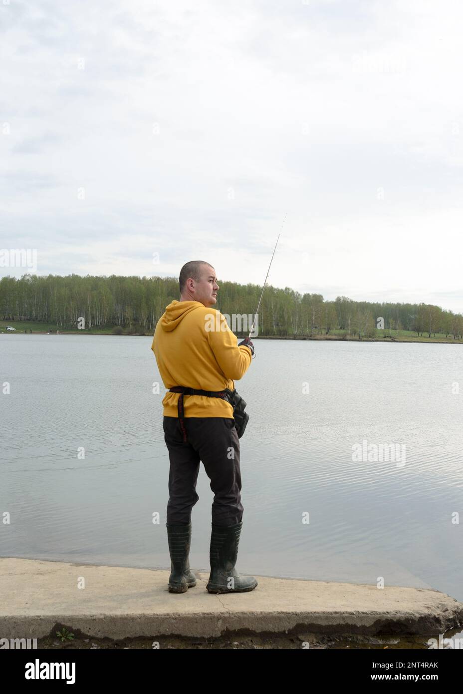 https://c8.alamy.com/comp/2NT4RAK/russian-modern-male-fisherman-fishes-on-an-ultralight-spinning-rod-in-the-rain-on-a-lake-in-siberia-2NT4RAK.jpg