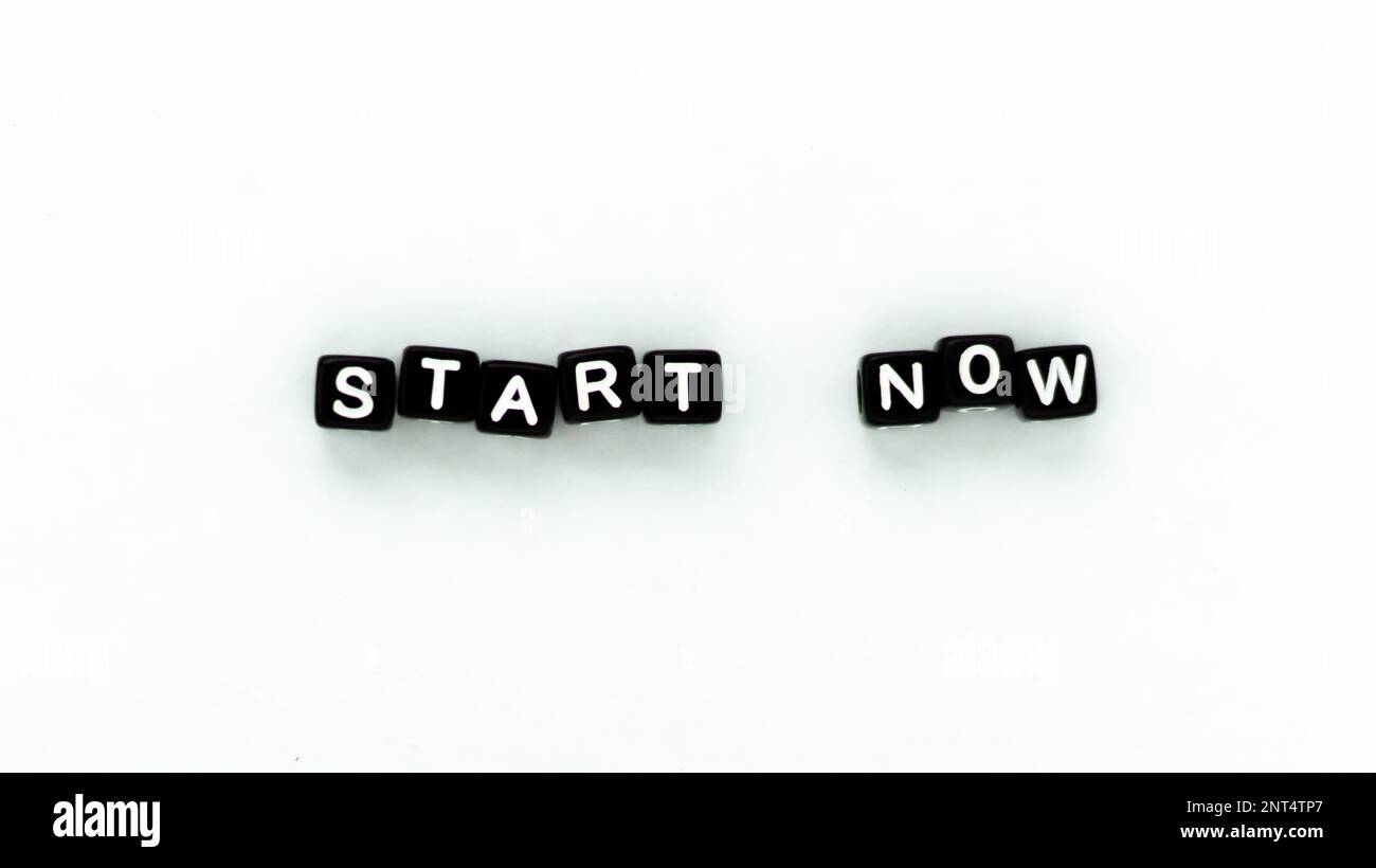 Start Now motivation quote in black letter Block beads on white background. Top view. Mock up  Stock Photo