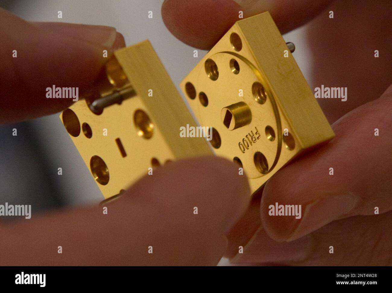 Brittney Abner, lead micro assembler with Micro Harmonics, holds pieces ...