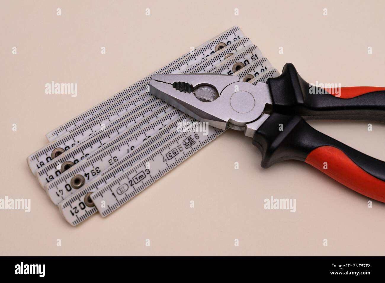 Pliers and a folding ruler lying on a light background. Close up. Stock Photo