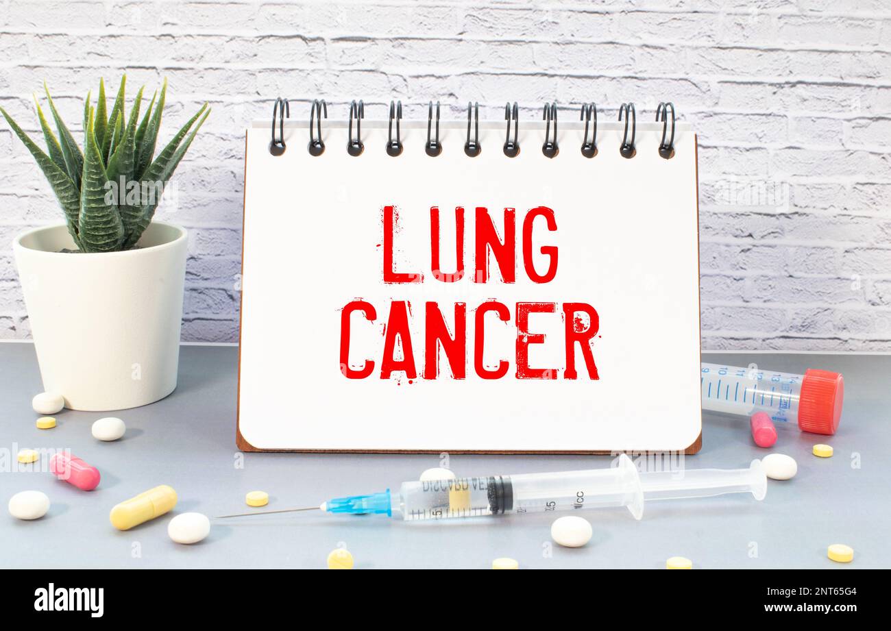 Paper with text LUNG CANCER on blue background with stethoscope and pills Stock Photo