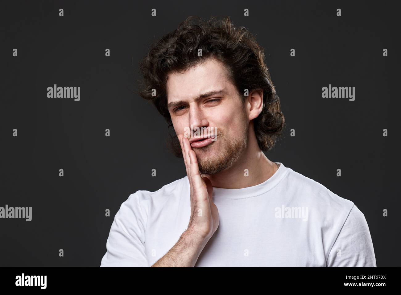 young man with toothache on dark gray background Stock Photo
