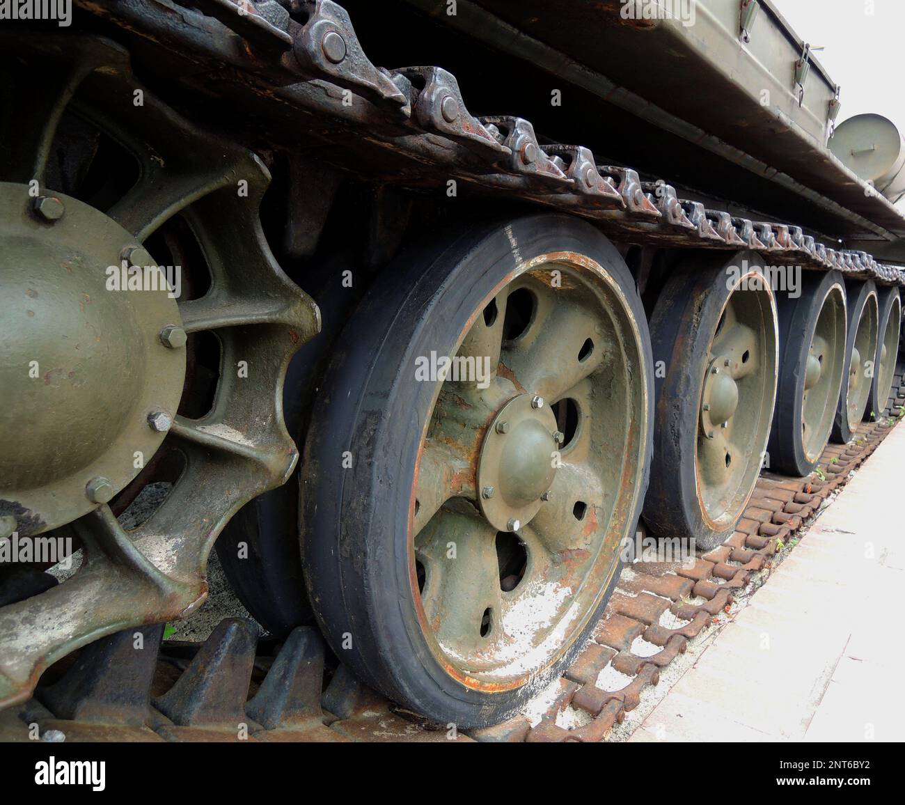 Tracks and rollers of a tracked tank packed with sand with traces of rust Stock Photo