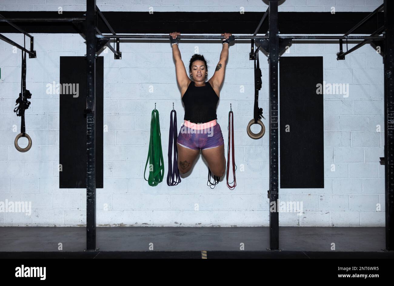 toes to bar woman pull ups 2 bars workout exercise at gym.Woman working
