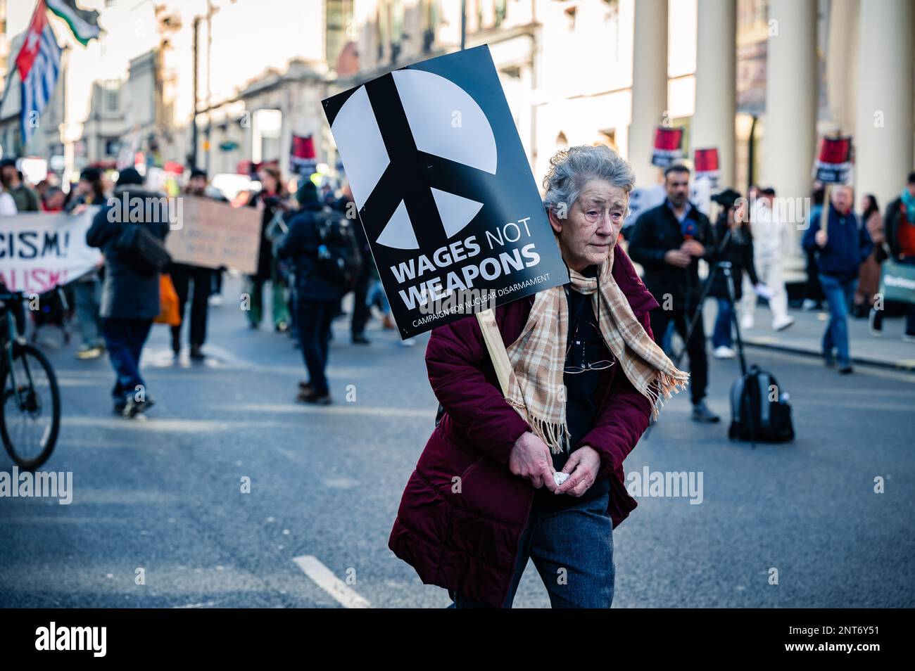 Woman holding a 'Wages not Weapons' sign at a Stop The War march in Trafalgar Square, London (February 2023). Stock Photo